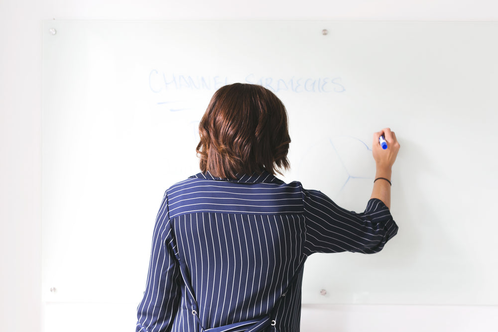 woman uses whiteboard in office