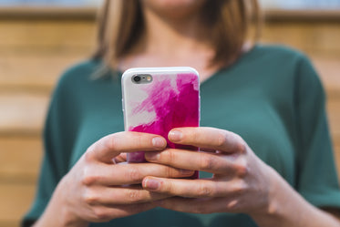 woman using pink smart phone