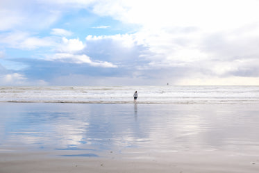 woman wades through water at beach