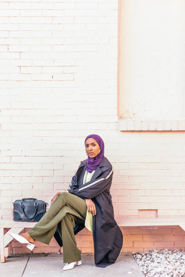 woman waits on bench