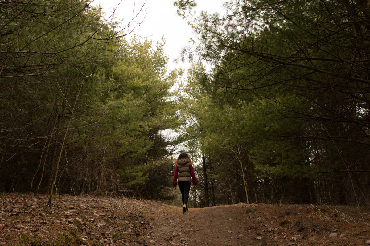 woman walking through forest clearing