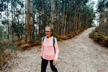 woman walks down a tree lined path