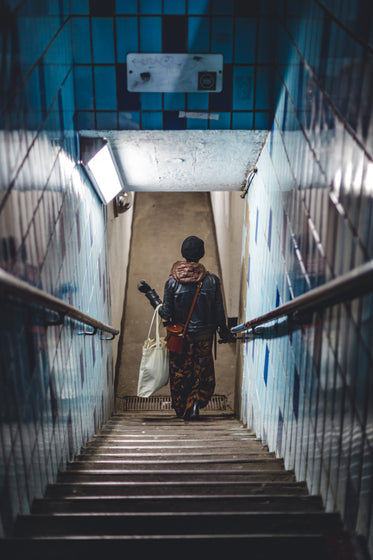 woman walks down steps to the subway