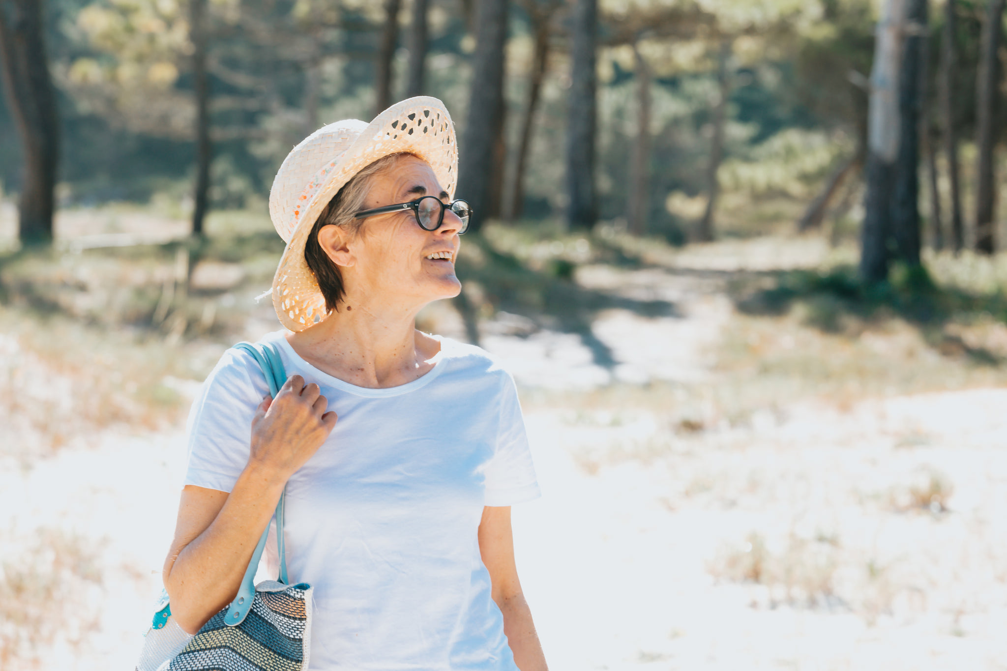 Woman Walks Outdoors During Summer Holding A Beach Bag