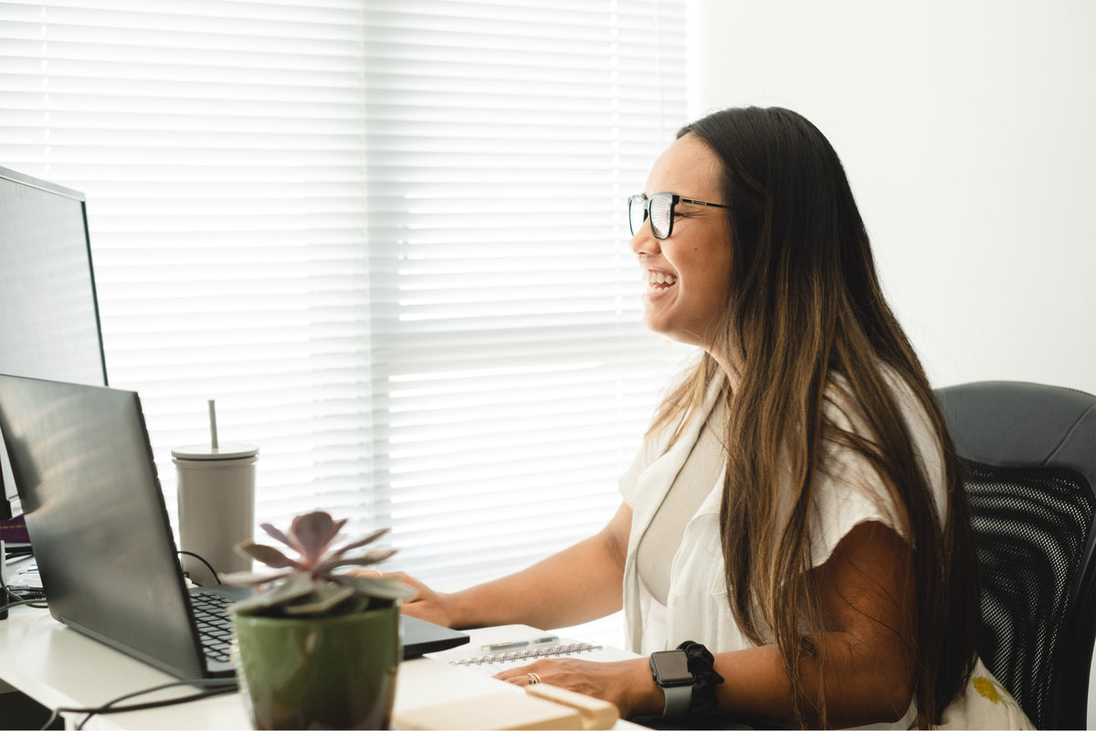 woman wearing glasses by her desktop monitor