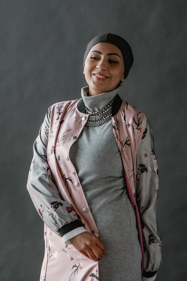 woman wearing headscarf in front of black background.