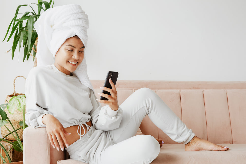 woman wearing sweats on mobile phone