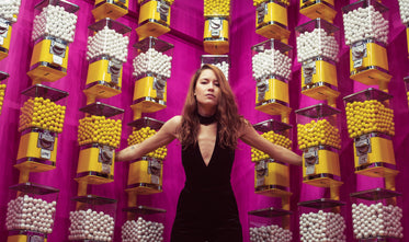 woman with arms outstretched into gumball machines