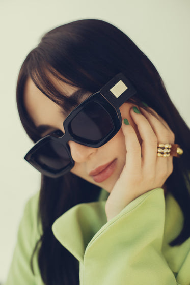 woman with bold sunglasses poses for the camera