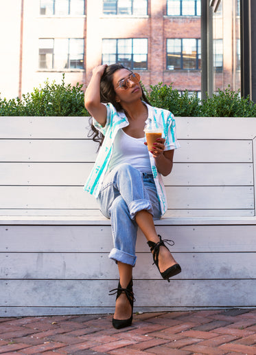 woman with coffee runs hands through hair