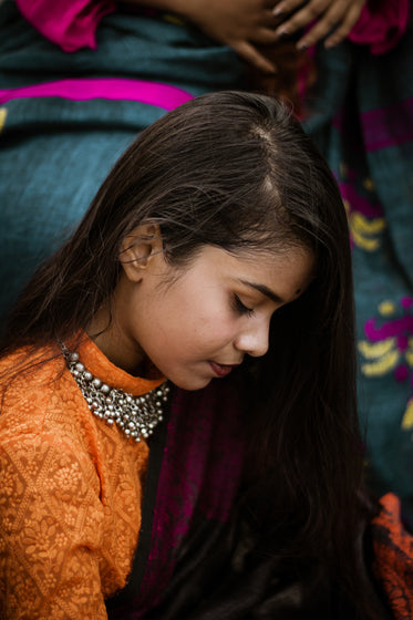 woman with long straight hair looks down