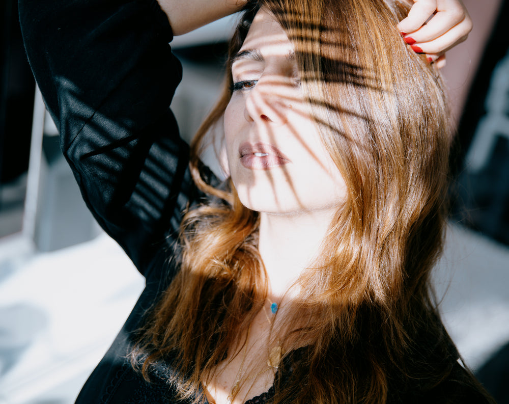 woman with the shadow of a spiky plant on her face