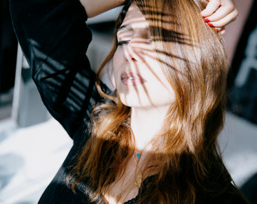 woman with the shadow of a spiky plant on her face