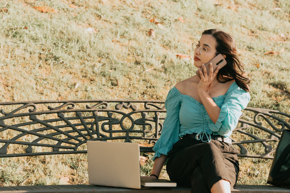 woman working outdoors holds a phone to her ear