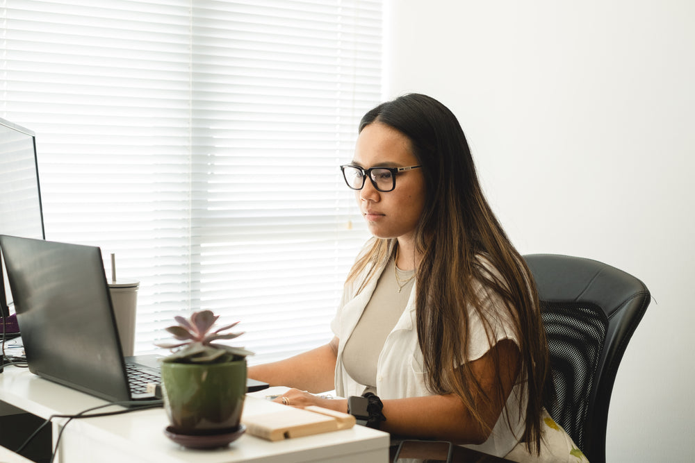 woman works at a two tier desk and concentrates