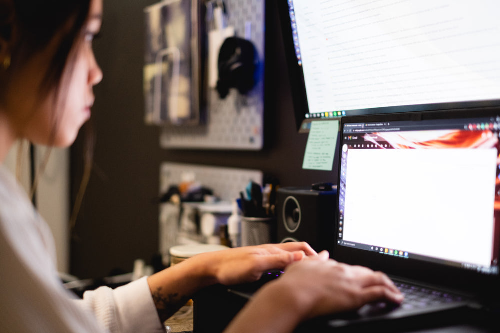 woman works on bright computer screens