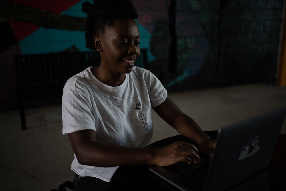 woman works on her laptop in front of colorful wall