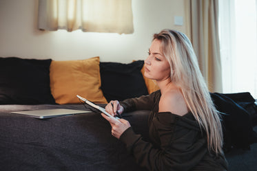 woman writes in a open journal as wellness practice