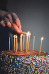 womans hand liting birthday candles