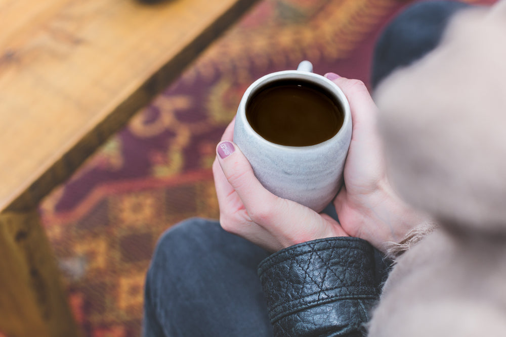 womans hands holding coffee