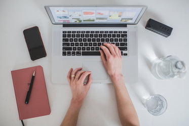 woman's hands typing on laptop