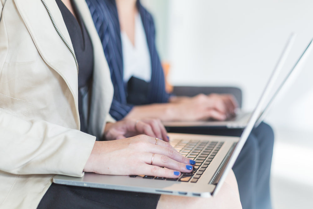 womans hands working on laptop