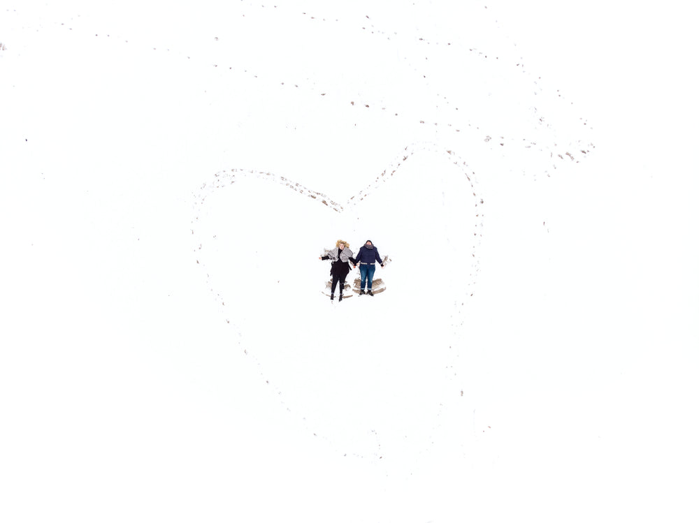 women carve out snow angels