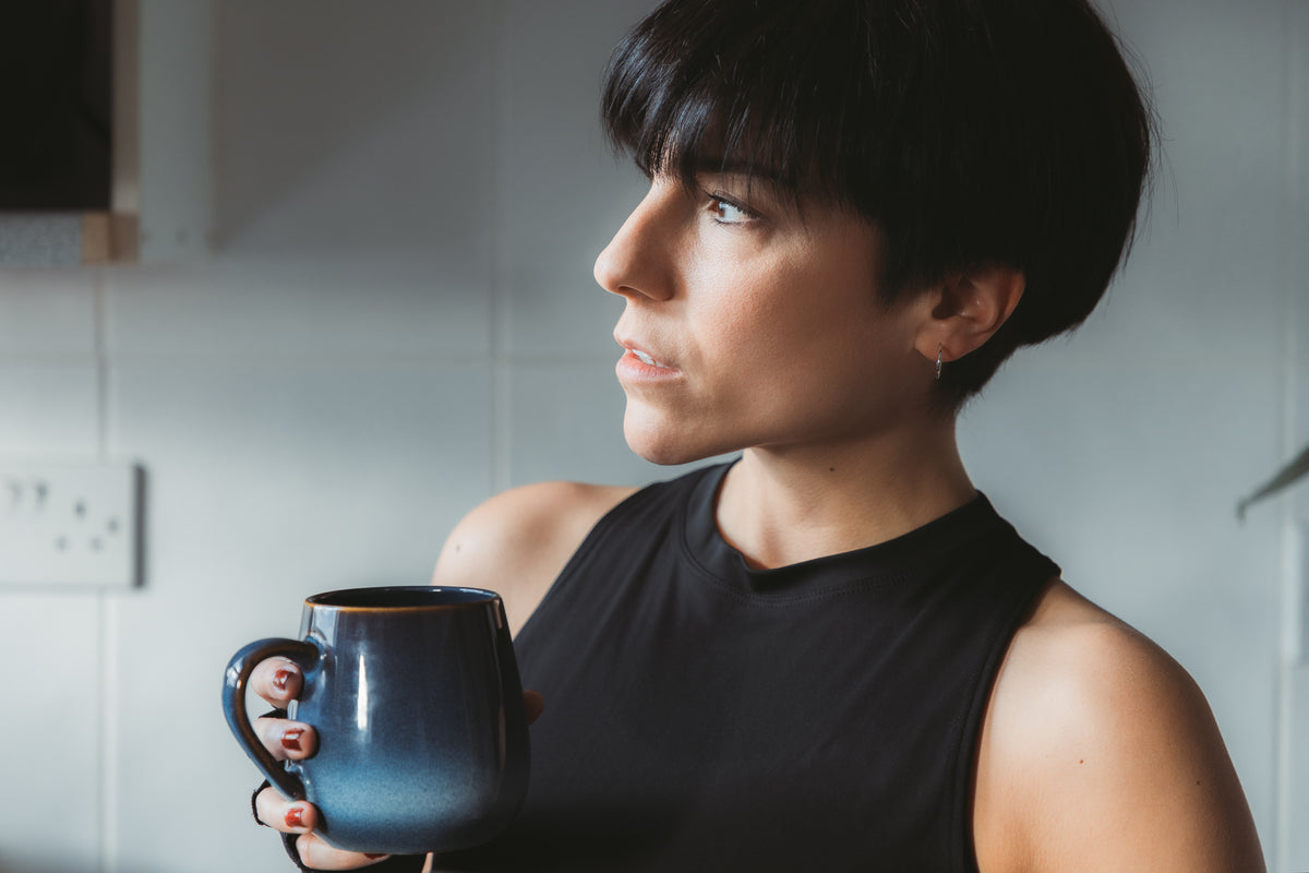 women holds a mug and looks to the left
