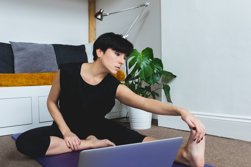 women leans forward holding her outstretched leg