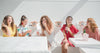 women sipping cocktails in a white room