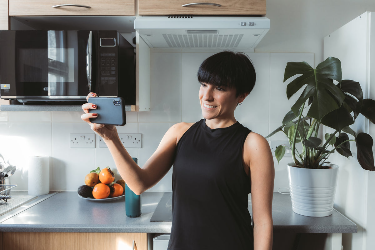 women stands in the kitchen and takes a selfie