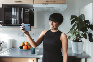 women stands in the kitchen and takes a selfie