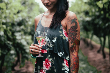 women's fashion tattoo holding glass of wine