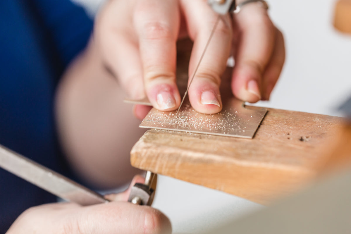 womens hand cutting metal surface