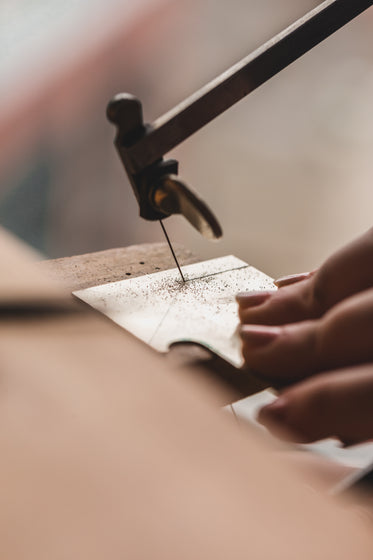 womens hand sawing through metal