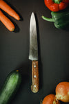 wood handled knife surrounded by vegetables