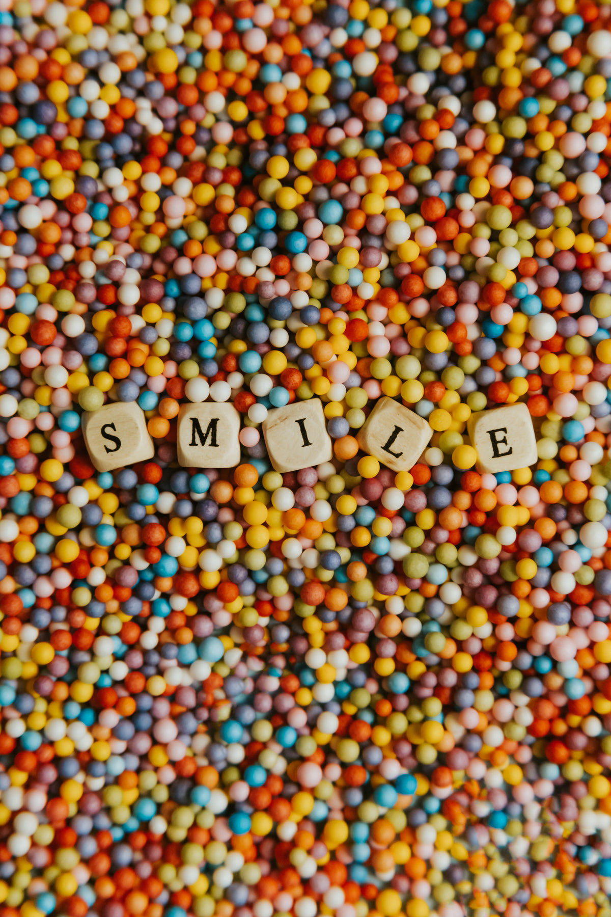 wooden block spell out smile laying on colorful dots