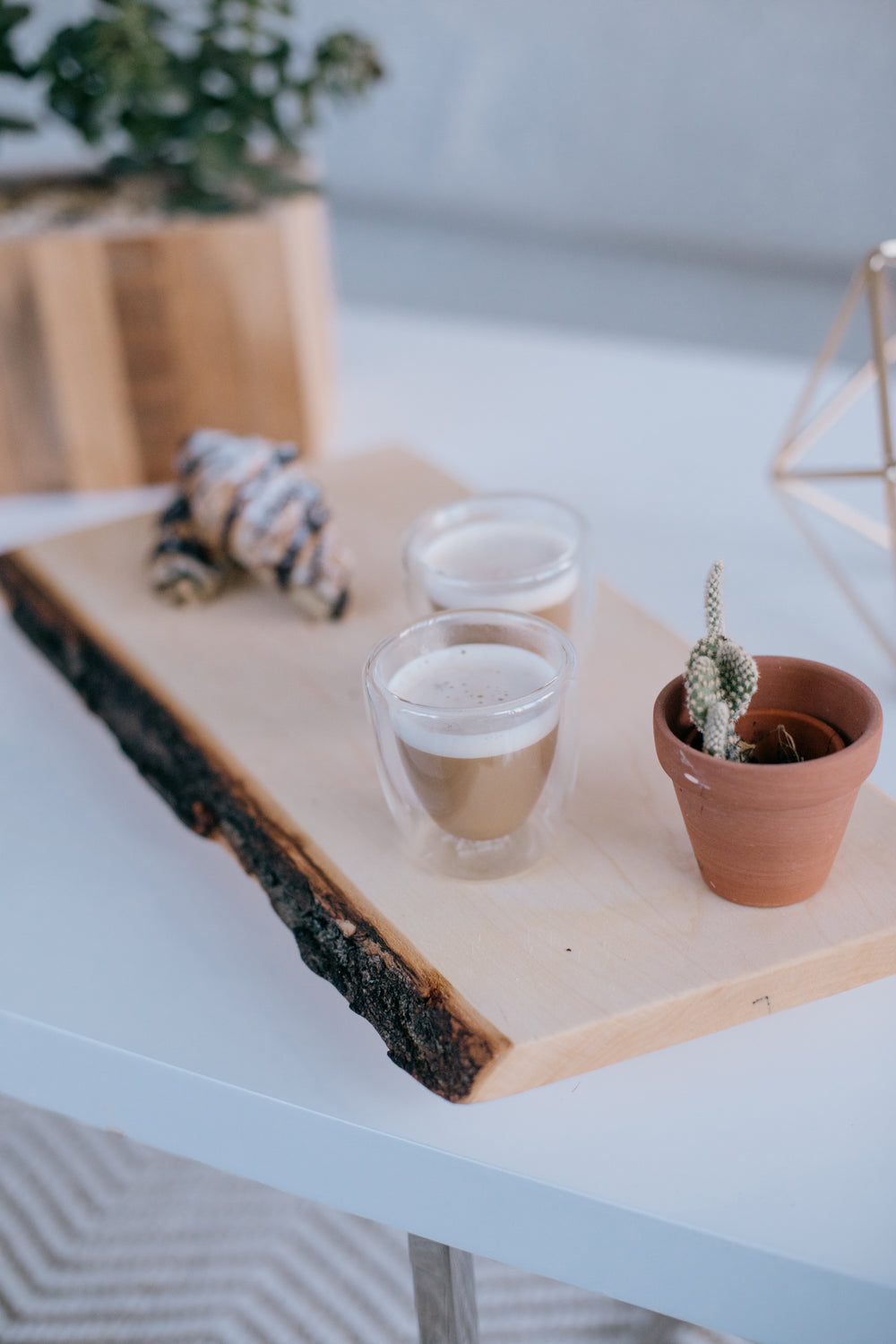 wooden board with lattes a cactus and croissants