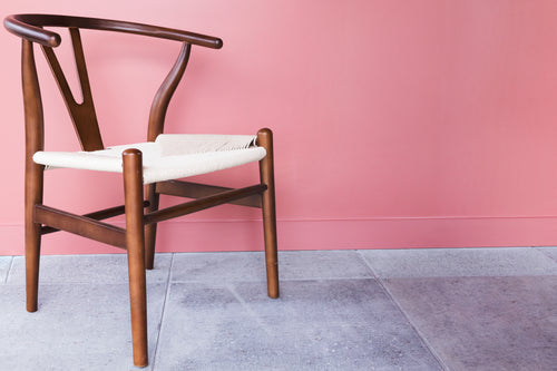 wooden chair by pink wall