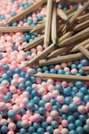 wooden colored pencils scattered on pink and blue balls