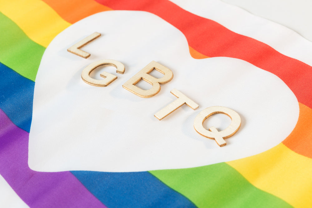 wooden lgbtq letters in heart pride flag