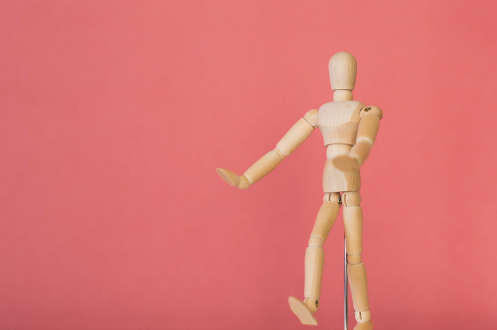 wooden model against pink background