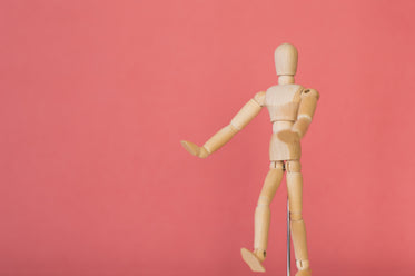 wooden model against pink background