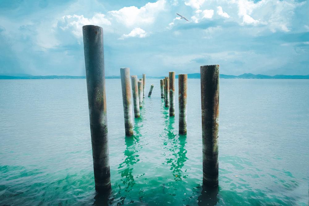 wooden pegs lead into aqua blue water