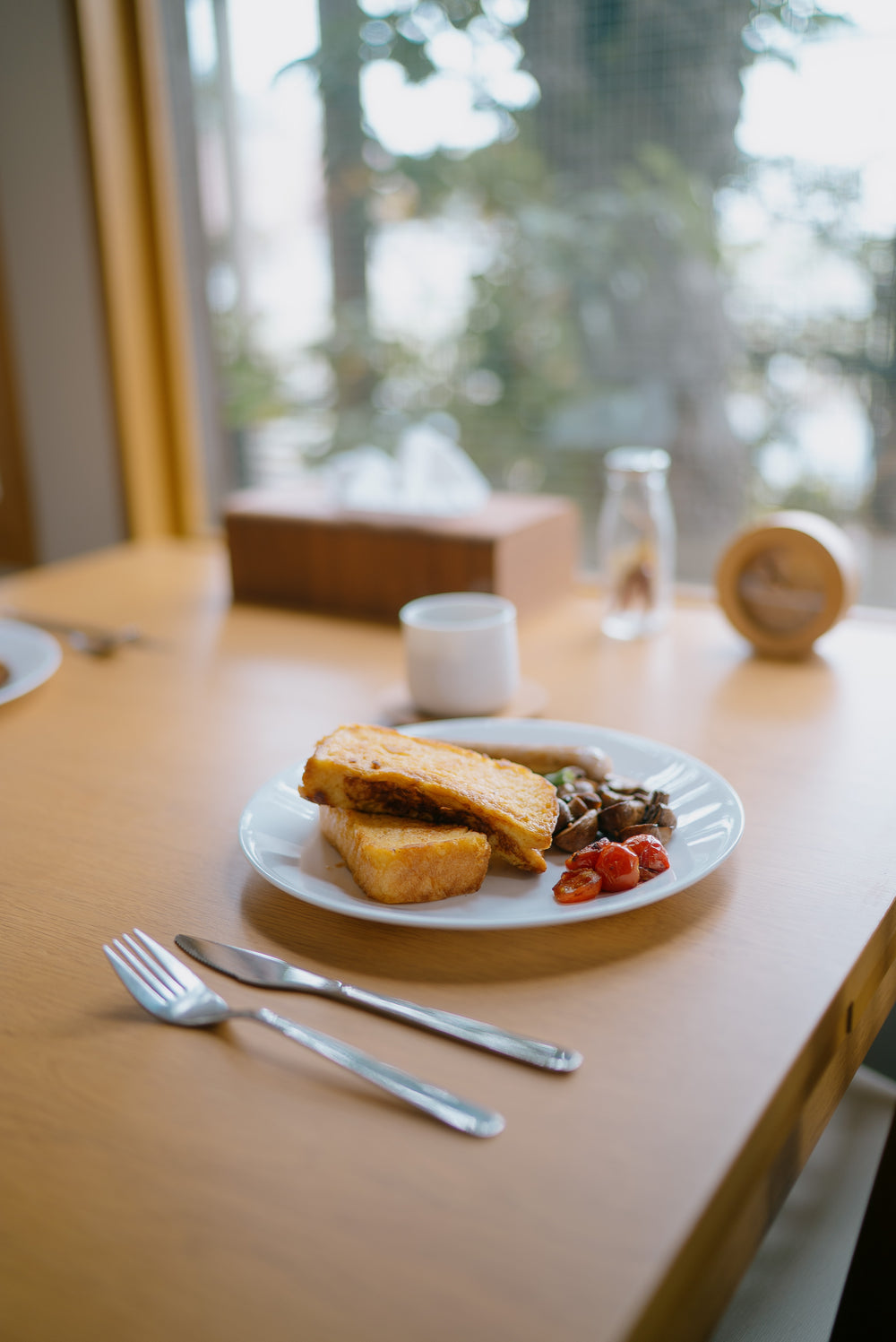 wooden table at a window set for lunch