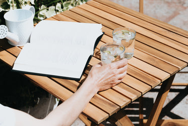 wooden table with a book and drinks