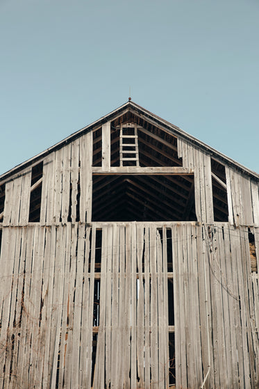 worn wooden barn against a clear blue sky