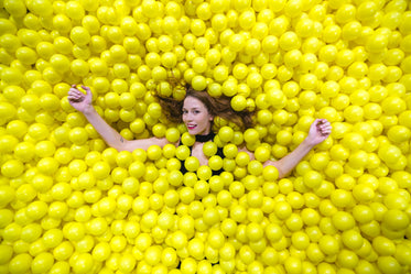 yellow ball pool with happy woman