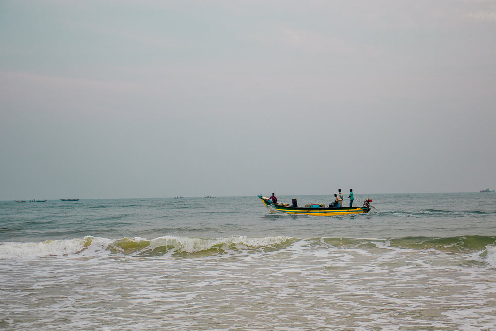 yellow boat on wavy waters on overcast day