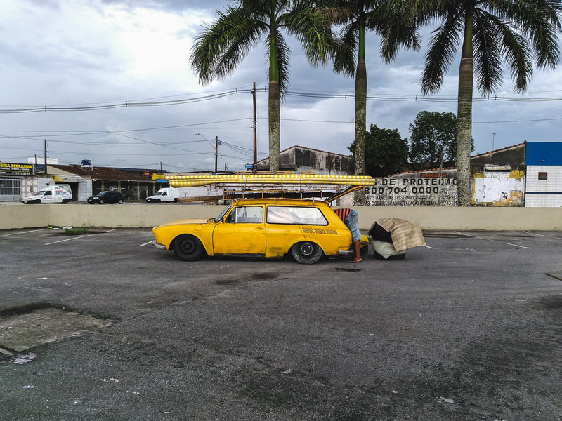 yellow car in tropics - a yellow car parked in a parking lot with a yellow car